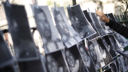 A man hangs images of murdered journalists during a demonstration