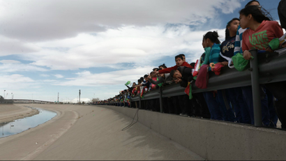 Residents of Ciudad Juarez form a human wall along the border with the US.