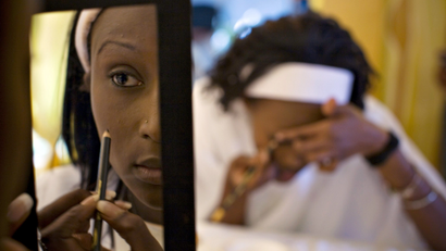 A contestant hoping to become a supermodel is reflected in a mirror while applying make-up during a competition in Kenya's capital Nairobi August 25, 2008. New York's Ford modelling agency scoured remote areas of Kenya hoping to find a potential supermodel and on Thursday selected 15 finalists, including one rural contestant who had never before worn high heels.