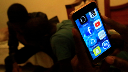 A Sudanese man holds his phone with restricted internet access social media platforms, in Khartoum