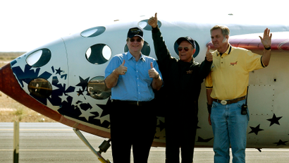 Pilot Michael Melville is flanked by project backer Paul Allen, left, and aerospace engineer Burt Rutan as they celebrate next to SpaceShipOne after landing at Mojave, Calif., airport Monday, June 21, 2004. SpaceShipOne is a privately developed rocket plane that became the world's first commercial manned space vehicle and the first non-governmental flight to leave the Earth's atmosphere.