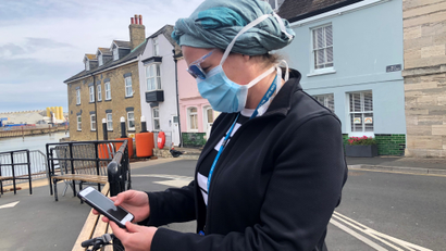 UK National Health Service employee looks at new NHS app to trace contacts with people potentially infected with the coronavirus disease (COVID-19) being trialled in the UK.