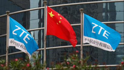 A Chinese national flag and two flags bearing the name of ZTE fly outside the ZTE R&D building in Shenzhen