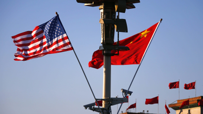 U.S. (L) and Chinese national flags flutter on a light post at the Tiananmen Square ahead of a welcoming ceremony for U.S. President Barack Obama, in Beijing, November 12, 2014. REUTERS/Petar Kujundzic (CHINA - Tags: POLITICS) - RTR4DSIF