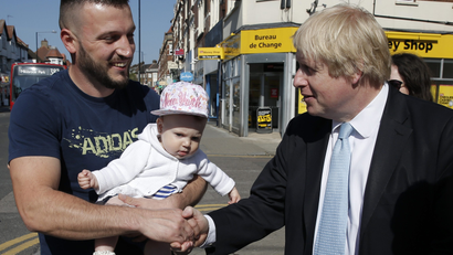 London's Mayor Boris Johnson greets a man with a baby whilst campaigning for the local Conservative candidate in Finchley, north London, April 21, 2015.
