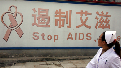 A nurse looks at a sign regarding AIDS as she walks in the grounds of Beijing You An Hospital October 17, 2008. Women must be more involved in the fight against HIV/AIDS, a disease increasingly being spread through sex, and men must also be encouraged to respect women more, a senior U.N. official said on Friday. Nafis Sadik, U.N. special envoy for HIV/AIDS in the Asia-Pacific region, told a poverty alleviation conference in Beijing that lack of respect for women was helping drive the spread of the virus. About 700,000 people live with HIV/AIDS in China and it is now mainly transmitted through sex. REUTERS/David Gray (CHINA) - RTX9NAO