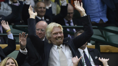 Entrepreneur Richard Branson (R) and other spectators perform a Mexican wave on Centre Court at the Wimbledon Tennis Championships, in London June 30, 2014. REUTERS/Toby Melville