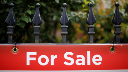 A real estate sign is seen hanging on a fence in front of a house for sale in Ottawa, Ontario, Canada.