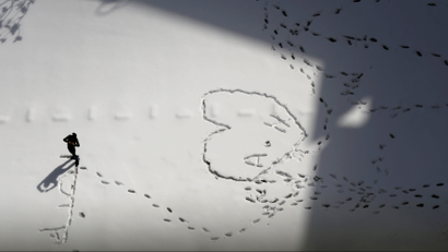 A man makes patterns in the snow during a heavy snowstorm.