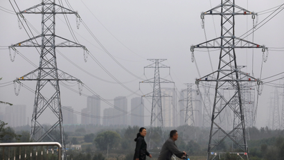 People walk past electricity pylons in Shenyang, Liaoning province, China.