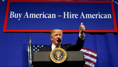 US President Donald Trump in front of a 'Buy America Hire America' sign
