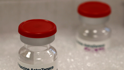 Two vials labeled "Covid-19 vaccine" in ice.