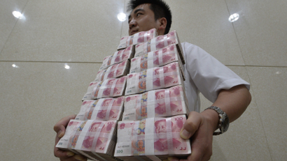 An employee carries bundles of 100 yuan Chinese bank notes to store after counting at a bank in Taiyuan, Shanxi province July 4, 2013. Chinese authorities allowed short-term borrowing costs to spike to record levels on June 20, sending a blunt but effective message to banks that it was determined to bring risky credit growth under control. The crackdown, however, has only increased China Inc's reliance on shadow banking and its various components, underscoring the system's importance as China's rigid financial industry maneuvers through an economic slowdown. Picture taken July 4, 2013.