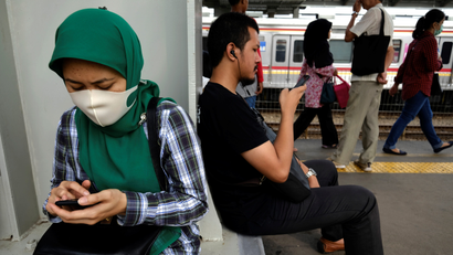 Commuters use their smartphones as they wait for the train during the morning rush at Tanah Abang train station in Jakarta, Indonesia, June 13, 2017.
