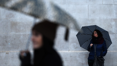 People shelter under umbrellas on a rainy day in central London, Britain