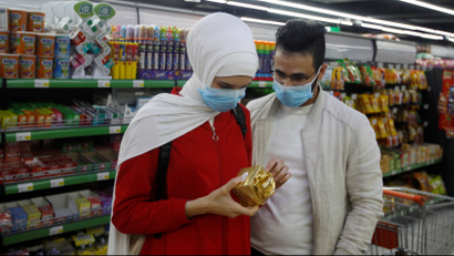 A man and his wife wear protective face masks at a supermarket