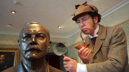 Sherlock Holmes investigates a statue with his pipe and hat
