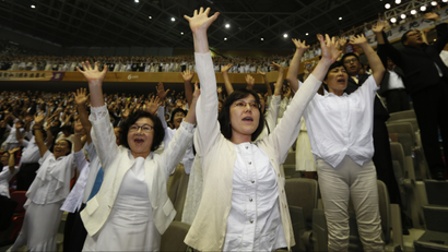 Believers of the Unification Church give three cheers as they attend the first death anniversary of evangelist Reverend Moon Sun-myung by the lunar calendar, in Gapyeong, about 60 km (37 miles) northeast of Seoul August 23, 2013. Moon, founder and head of the Unification Church with millions of followers around the world, died on September 3, 2012. Born in what is now North Korea in 1920, Moon founded the church soon after the Korean War that ended in 1953, rapidly expanding the ministry internationally and building a business at the same time that served as the backbone of the empire. REUTERS/Lee Jae-Won