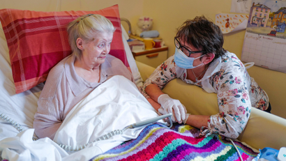 A care home's resident holds her daughter's hand