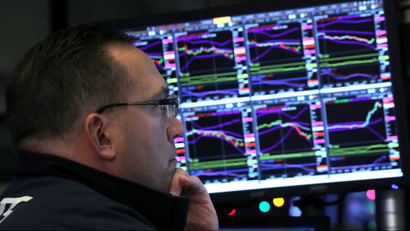 A trader looks at price monitors as he works on the floor at the New York Stock Exchange (NYSE) in New York City