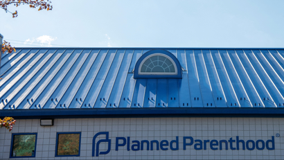 A Planned Parenthood building with a blue roof against a clear sky.