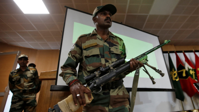 An Indian Army soldier displays a seized rifle during a news conference in Srinagar