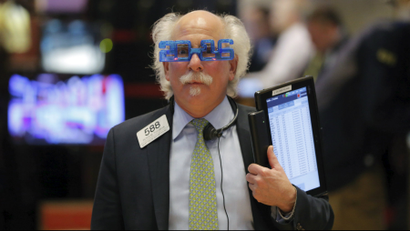 Trader Peter Tuchman wears plastic glasses to celebrate the last trading day of 2015 as he works on the floor of the New York Stock Exchange.