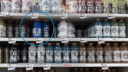 Photo of a shelf at a grocery store of newly designed Gatorade bottles in 28 oz. with one 32 oz. bottle in an older design.