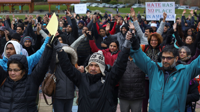 People hold hands during a vigil in honor of Srinivas Kuchibhotla, an immigrant from India who was recently shot and killed in Kansas, at Crossroads Park in Bellevue, Washington