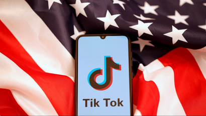 Tik Tok logo is displayed on the smartphone while standing on the U.S. flag in this illustration picture taken, November 8, 2019.