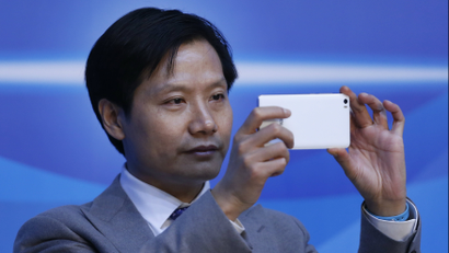 Lei Jun, founder and chief executive officer of Xiaomi, uses a phone during a session of the second annual World Internet Conference in Wuzhen town of Jiaxing, Zhejiang province, China