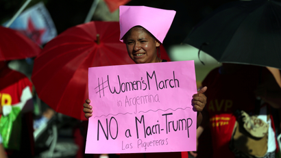 A woman wear a pink protest hat, symbol of the anti-Trump women's march, during a protest outside the U.S. embassy in Buenos Aires, Argentina, January 20, 2017. The signs read "No to Trump - Leftist socialist (party)" REUTERS/Marcos Brindicci - RTSWLIU