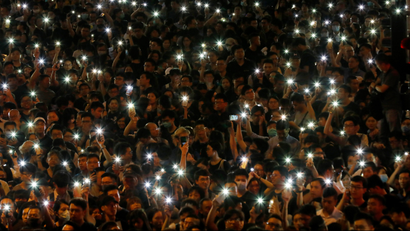 Attendees hold up their lit mobile phones during a rally by civil servants to support the anti-extradition bill protest in Hong Kong, China.