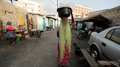 A street vendor carries a basin filled with water sachets in Dakar.