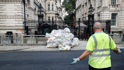 Bags containing plastic waste are dumped outside Downing Street by Greenpeace activists in London.
