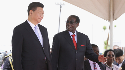 Chinese President Xi Jinping talks with Zimbabwean President Robert Mugabe on arrival for a state visit in Harare, Zimbabwe December 1, 2015.