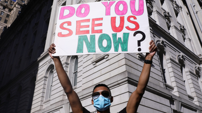 A demonstrator holds a sign during a protest against police brutality
