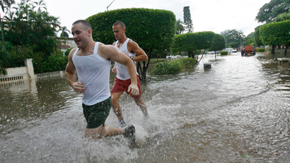 Joggers run through flooded streets after torrential rains hit Havana August 26, 2008. Weather forecasters predicted on Tuesday that Hurricane Gustav would skirt the western coast of Cuba and enter the Gulf of Mexico as a powerful Category 3 hurricane with winds in excess of 100 mph by Sunday.