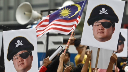 Protesters hold portraits of Jho Low illustrated as a pirate during a protest in Kuala Lumpur, Malaysia, Saturday, April 14, 2018. Protesters gathered Saturday in Kuala Lumpur to call for the arrest of businessperson Jho Low over the alleged multibillion-dollar theft of funds from a Malaysian state investment company.