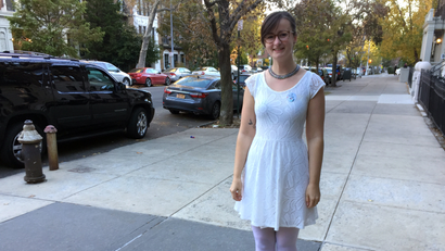 Lucy Bonner of Brooklyn, N.Y., poses Tuesday, Nov. 8, 2016, dressed in white after voting for Hillary Clinton. Some Clinton supporters wore the color white in honor of the suffragettes, who wore white when they fought for women's right to vote in the early 1900s. There was also a movement among some Clinton supporters to wear pantsuits Tuesday in a nod to Clinton's usual outfit, including a Facebook group called Pantsuit Nation. (AP Photo/Beth J. Harpaz)