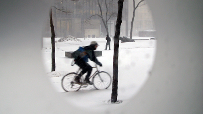 A bicycle courier cycles through a building courtyard during a snowstorm in Toronto, March 1, 2007.