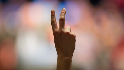 A raised hand giving the peace sign