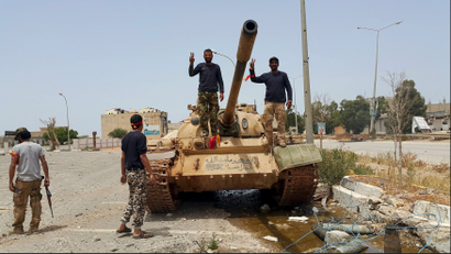 Members of the Libyan pro-government forces gesture as they stand on a tank in Benghazi, Libya, May 21, 2015.