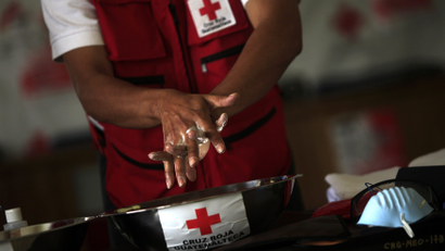 A red cross worker washes hands