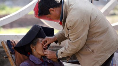 A dentist checks the teeth of a patient in a street market in Xichang, southwest China's Sichuan province.