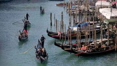 Gondoliers row along the Grand Canal during carnival season in Venice