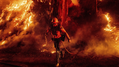 A firefighter against red smoke and flame