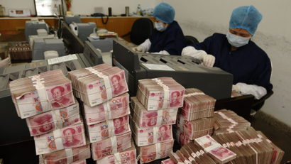 Employees count yuan banknotes at a branch of Bank of China in Changzhi