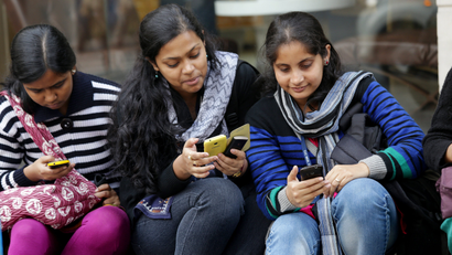 Indian students browse the internet with their smartphone.