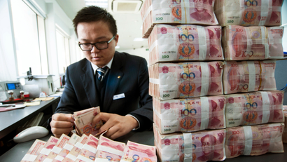 A clerk counts Chinese 100 yuan banknotes at a branch of China Construction Bank in Nantong, Jiangsu province December 2, 2014. China stocks leapt on Tuesday, as a mainland rally gained fresh steam, with investors pouring into brokerages and banking shares, widening the valuation gap with Hong Kong shares. Bank of China Ltd, Agricultural Bank of China Ltd and China Construction Bank Corp were all up close to 5 percent in late afternoon trading.